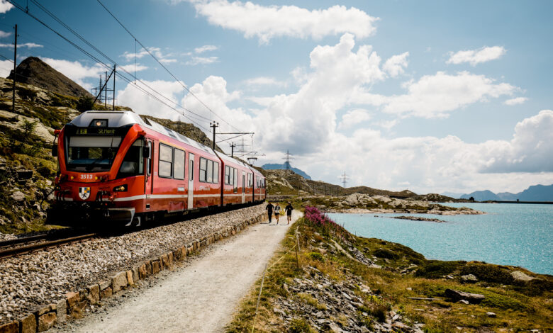 Běžci na stezce Piz Bernina u jezera Lago Bianco, vlaková souprava Rhétských drah (RhB). Foto: Switzerland Tourism